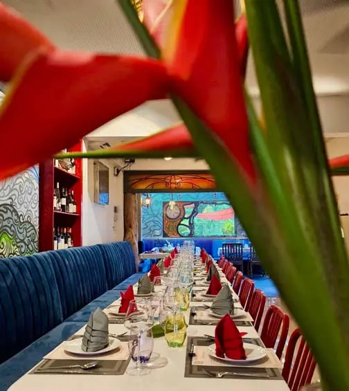 The long dining room with blue banquettes and red napkins at Brussels Bistro